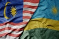 big waving realistic national colorful flag of malaysia and national flag of rwanda