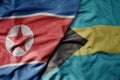 big waving realistic national colorful flag of north korea and national flag of bahamas