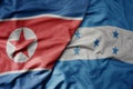 big waving realistic national colorful flag of north korea and national flag of honduras