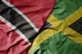 big waving realistic national colorful flag of trinidad and tobago and national flag of jamaica Royalty Free Stock Photo