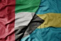 big waving realistic national colorful flag of united arab emirates and national flag of bahamas