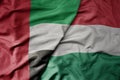 big waving realistic national colorful flag of united arab emirates and national flag of hungary