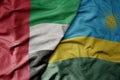 big waving realistic national colorful flag of united arab emirates and national flag of rwanda