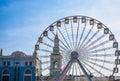 Big wheel against the background of the blue sky and an old city architecture Kiev, Ukraine. Amusement park. Area.