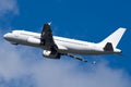 Big white airplane flying high against a blue cloudy sky on a sunny day Royalty Free Stock Photo