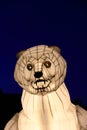 Big white artificial polar bear head in the street at night