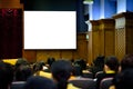 The big white blank screen in the big meeting room with blurred many people Royalty Free Stock Photo