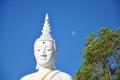 Big white Buddha sculpture and small full moon