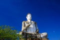 Big white Buddha statue raising high contrasting with blue cloudless sky at Wat Ek Phnom, near Battambang, Cambodia Royalty Free Stock Photo