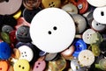 Big white button laying on other smaller colorful buttons