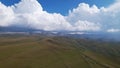 Big white clouds over green hills and mountains. Royalty Free Stock Photo