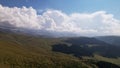 Big white clouds over green hills and mountains. Royalty Free Stock Photo