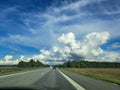 Big white clouds over the highway Royalty Free Stock Photo
