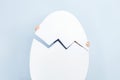 Big white dehiscent egg on the background of blue wall. Royalty Free Stock Photo