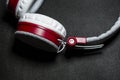 Big and white earphones for listening of music. Red plastic and skin. On a black background. Modern technologies. Portability. Royalty Free Stock Photo