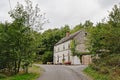 Big white house along a countryside road with trees in Ardennes