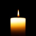 Big white lighted candle isolated on black background. Royalty Free Stock Photo