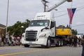 A big white semi truck driving through the fourth of July parade