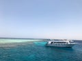 Big white ship, boat, cruise tourist liner on blue azure sea, ocean with reefs against the blue sky Royalty Free Stock Photo