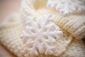 Big white snowflake on white knitted scarf background Royalty Free Stock Photo