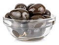 Big whole black olives in a small transparent glass round bowl isolated on white background Royalty Free Stock Photo