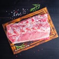 Big whole piece of pork meat with seasoning on chopping board on