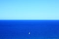 Big blue ocean with small white sailing boat, vastness Royalty Free Stock Photo