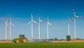 Big wind turbines to generate electrical power, green ecofriendly energy at blue sky standing at farm green field with working Royalty Free Stock Photo