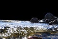 Big windy waves splashing over rocks. Wave splash in the lake isolated on black background. Waves breaking on a stony beach, formi Royalty Free Stock Photo