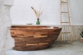 Big wooden bath in modern eco interior of white bathroom