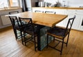 A big wooden dining table with glass blocks and metal wicker chairs and pillows in modern scandinavian an eat-in kitchen, against Royalty Free Stock Photo