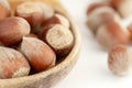 Big wooden spoon or plate with bunch of not peeled hazelnuts isolated on white background macro Royalty Free Stock Photo