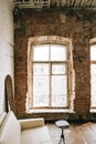 Big wooden window with white sofa in old vintage living room with brick walls Royalty Free Stock Photo