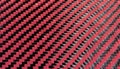 Red woven Black carbon fiber composite material background close up view Royalty Free Stock Photo