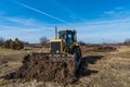 A big yellow bulldozer pushes the ground and makes a new road Royalty Free Stock Photo