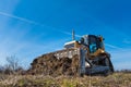 A big yellow bulldozer pushes the ground and makes a new road Royalty Free Stock Photo