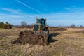 A big yellow bulldozer pushes the ground and makes a new road