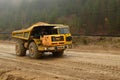 Big yellow diesel quarry dumper at work. Heavy mining truck transporting sand and clay Royalty Free Stock Photo