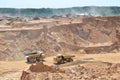 Big yellow dump truck transporting sand in an open-pit mining quarry. Mining quarry for the production of crushed stone, sand and