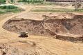 Big yellow dump truck transporting sand in an open-pit mining quarry. Mining quarry for the production of crushed stone, sand and