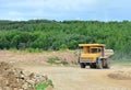 Big yellow dump truck working in the limestone open-pit. Loading and transportation of minerals in the dolomite mining quarry. Royalty Free Stock Photo