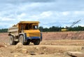 Big yellow dump truck working in the limestone open-pit. Loading and transportation of minerals in the dolomite mining quarry. Royalty Free Stock Photo