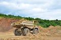 Big yellow dump truck working in the limestone open-pit. Loading and transportation of minerals in the dolomite mining quarry. Royalty Free Stock Photo