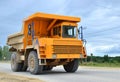 Big yellow dump truck working in the limestone open-pit. Loading and transportation of minerals in the dolomite mining quarry. Royalty Free Stock Photo