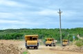 Big yellow dump trucks working in the limestone open-pit. Loading and transportation of minerals in the dolomite mining quarry. Royalty Free Stock Photo