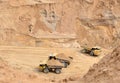 Big yellow dump trucks working in the open-pit. Royalty Free Stock Photo