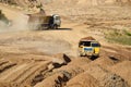 Big yellow dump trucks working in the open-pit. Royalty Free Stock Photo