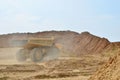 Big yellow dump trucks working in the open-pit. Transporting sand and minerals. Mining quarry for the production of crushed stone Royalty Free Stock Photo