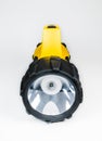 Big yellow flashlight hand held with adjustable angle isolated on white background..