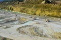 Big yellow mining trucks working in the limestone open-pit. Loading and transportation of minerals in the chalk open-pit. Royalty Free Stock Photo